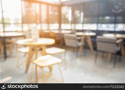 Blurred background cafe coffee shop with sun light. abstract of modern table design in restaurant.