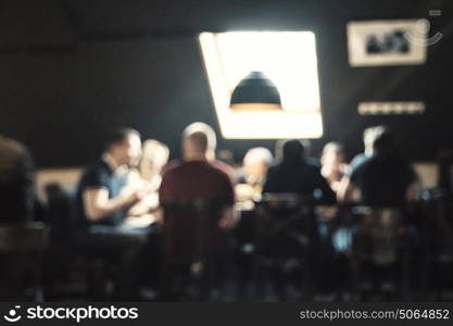 Blurred background Customers at restaurant sitting around a table blur background with bokeh. Customers at restaurant sitting around a table in front of bright window blur background with bokeh effect. Blurred cafe background