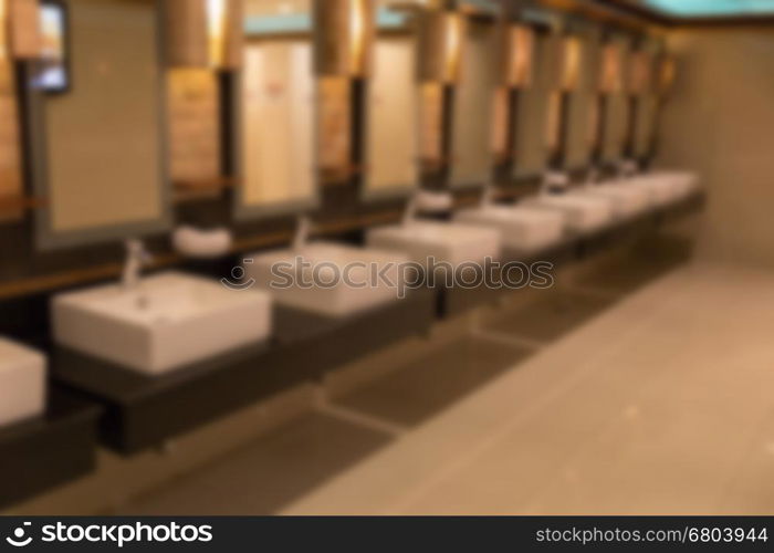 blurred background of faucet and sink in public bathroom restroom toilet