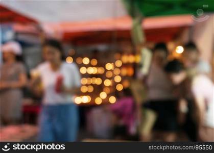 Blurred background of people shopping at night market festival for background usage