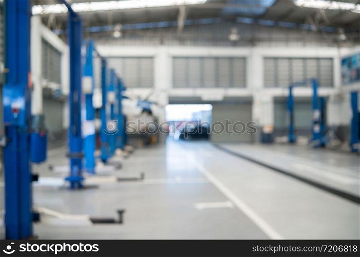 Blurred background of repairing garage with no people. blurry mechanics workshop car station and vehicle fixing and lifted automobile in service center