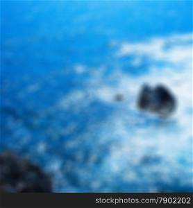Blurred background of rocks in the sea with foam, square image