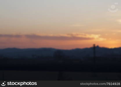 Blurred background of sunset over fields and small town, horizontal image