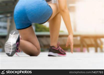Blurred background of woman runner in starting run position.