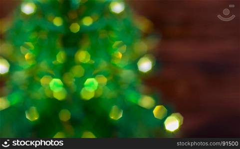 Blurred background with Christmas tree with bright yellow garlands