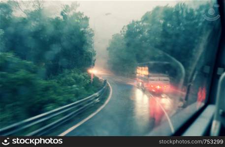 Blurred background with row of tree along highway motion blur at twilight in vintage color from window of car on rainy day