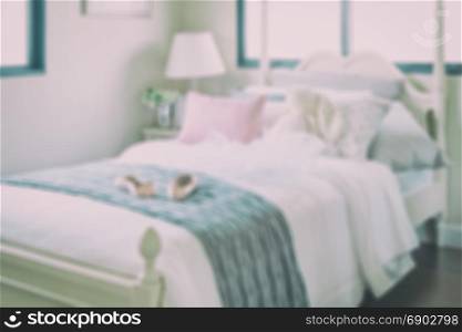 blurred bedroom with pillows and doll on white bed for background