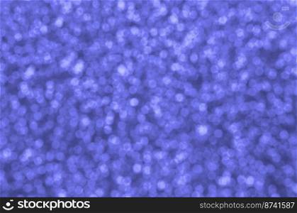 Blurred blue decorative sequins. Background image with shiny bokeh lights from small elements that reflect light. Blurred blue decorative sequins. Background image with shiny bokeh lights from small elements