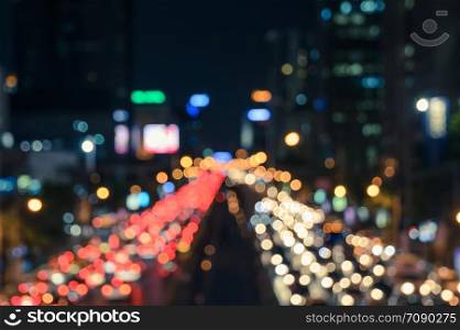 Blurred bokeh image of traffic jam in business area downtown. Defocused image of city night light