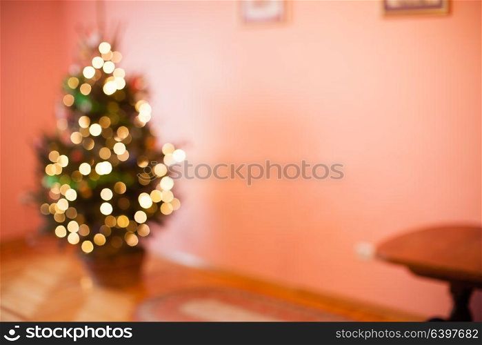 Blurred Christmas tree in basket in the empty room, copy space for text. Blurred Christmas tree