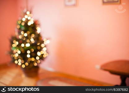 Blurred Christmas tree in basket in the empty room, copy space for text. Blurred Christmas tree