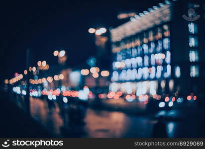 Blurred city at night. Bokeh. Beautiful abstract background with defocused buildings, cars, city lights, people. Colorful bokeh background with urban night scene. Design. Concept backdrop. Vintage . Blurred city at night. Bokeh