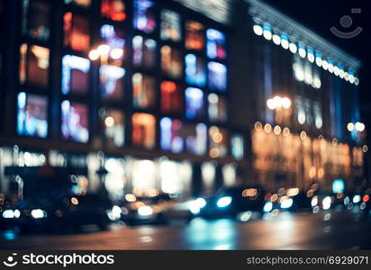 Blurred city at night. Bokeh. Beautiful abstract background with defocused buildings, cars, city lights, people. Colorful bokeh background with urban night scene. Design. Concept backdrop. Vintage . Blurred city at night. Bokeh