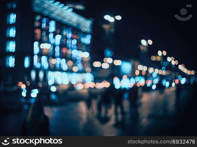 Blurred city at night. Bokeh. Beautiful abstract background with defocused buildings, cars, city lights, people. Colorful bokeh background with urban night scene. Design. Concept backdrop. Vintage . Blurred city at night. Bokeh