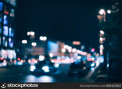 Blurred city at night. Bokeh. Beautiful abstract background with defocused buildings, cars, city lights, people. Colorful bokeh background with urban night scene. Design. Concept backdrop. Vintage . Blurred city at night. Bokeh