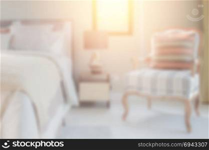 blurred classic style bedding with easy lounge chair in cozy bedroom for background