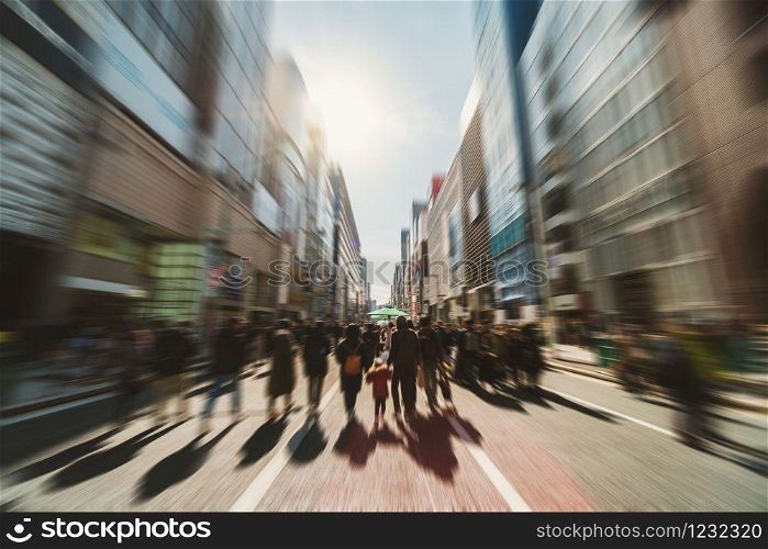 Blurred Crowd of unrecognizable business people walking on Zebra crossing in rush hour working day, Ginza walking street, Japan, blur business and people, lifestyle and leisure of Pedestrian concept