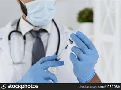 blurred doctor with medical mask holding syringe. High resolution photo. blurred doctor with medical mask holding syringe. High quality photo