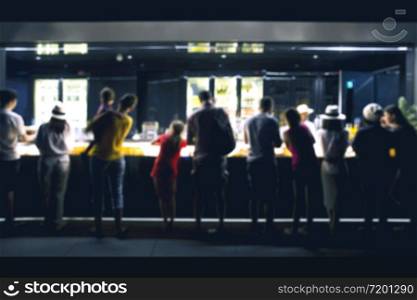 Blurred image Group of people man & women around a counter in a bar