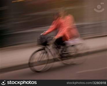 Blurred image of a person riding a bike in Paris France