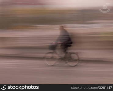 Blurred image of a person riding a bike in Paris France