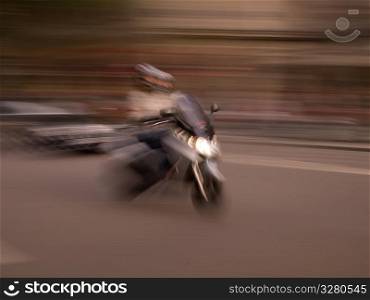 Blurred image of a person riding a scooter in Paris France
