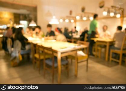 Blurred image of friends lunching and having fun at the restaurant