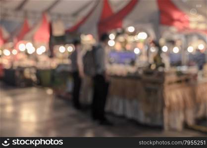 Blurred image of people shopping on street with bokeh, vintage color