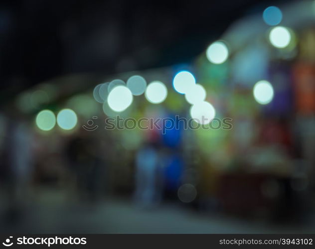 Blurred image of tourists walking at night market