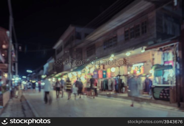 Blurred image of tourists walking at night market