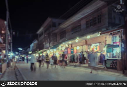 Blurred image of tourists walking at night market