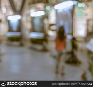 Blurred image of woman walking at shopping mall at night. Retro effect style photo