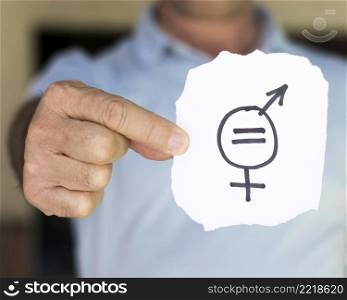 blurred man holding paper with gender symbols