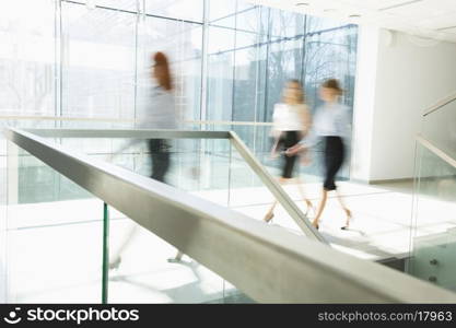 Blurred motion of businesswomen walking at office hallway