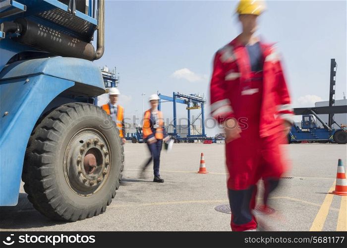 Blurred motion of workers walking in shipping yard
