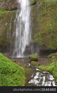 Blurred motion shot of waterfall and moss covered rocks