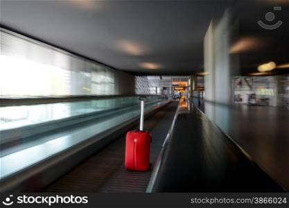 blurred moving escalator with red trolley in airport