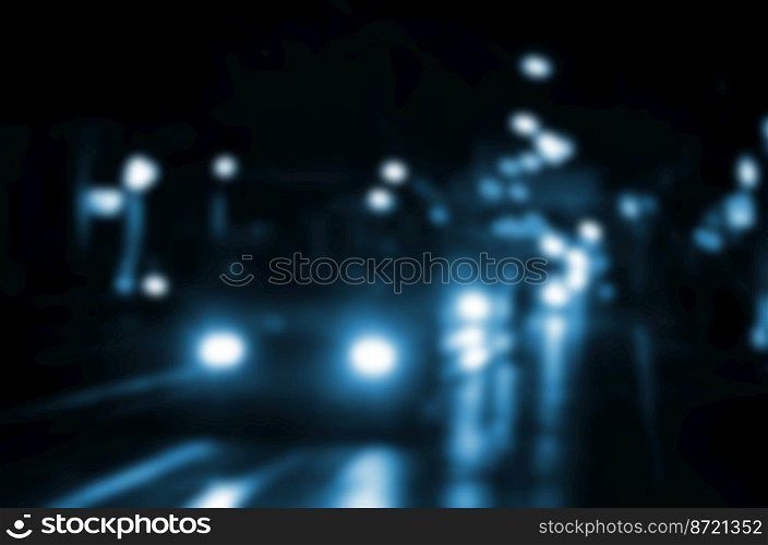 Blurred night scene of traffic on the roadway. Defocused image of cars traveling with luminous headlights. Bokeh Art
