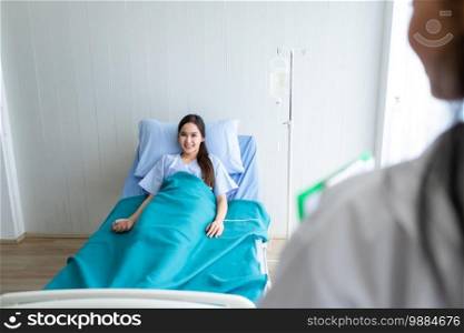 Blurred of female doctor therapeutic advising with positive emotions to A smile Asian young female patient on Bed in hospital background