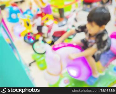 Blurred photo of a boy is happily playing in toy arcade games