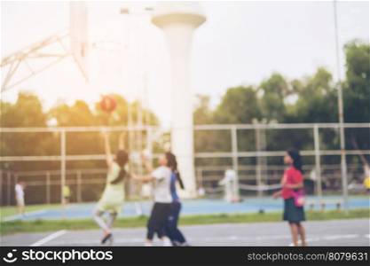 Blurred photo of Asian children are playing basketball with warm sun light from top right corner
