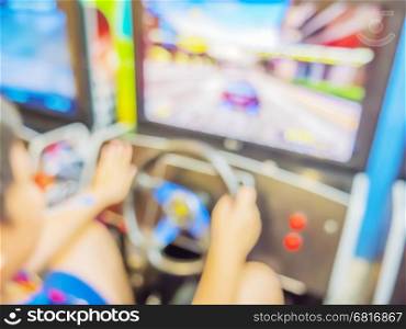 Blurred photo of boy is playing car racing simulator game