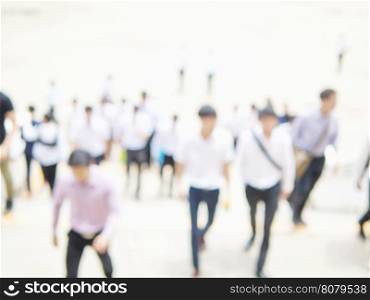 Blurred photo of crowded people is walking upstair