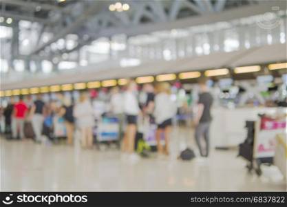 Blurred picture of long passenger queue waiting for check-in at airport check-in counters