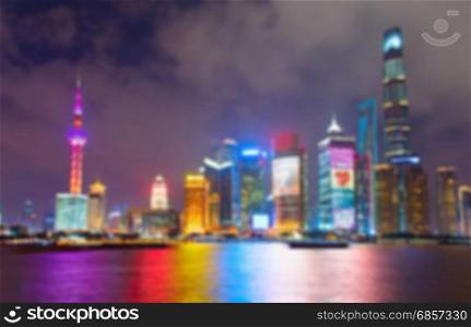 Blurred skyline of Shanghai Downtown at night with reflection in the river