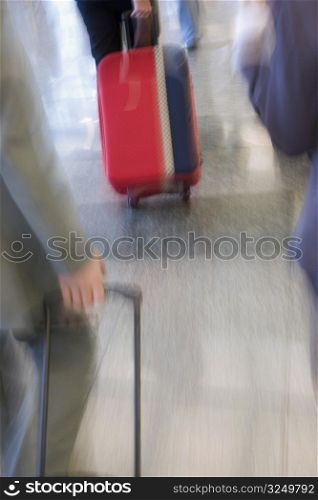 Blurred view of business executives pulling their luggage