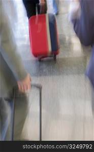 Blurred view of business executives pulling their luggage