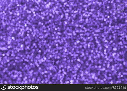 Blurred violet decorative sequins. Background image with shiny bokeh lights from small elements that reflect light. Blurred violet decorative sequins. Background image with shiny bokeh lights from small elements