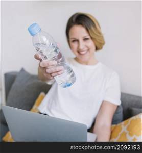 blurred woman with laptop showing water bottle