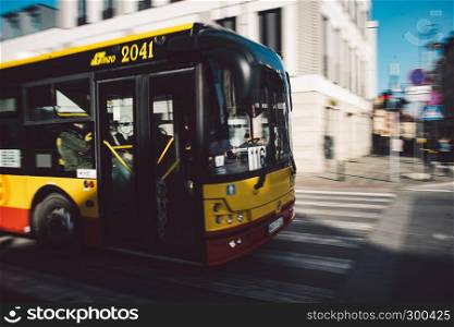 Blurred yellow and red public transport bus in Warsaw, Poland